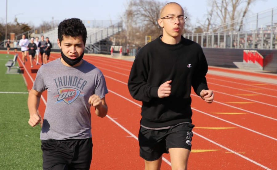 Warming+up+for+a+distance+run%2C+freshmen+James+Bourne+and+Korbon+Asencio+complete+a+lap+around+the+track.+Student-athletes+had+the+option+to+run+with+their+masks+on.+Some+students%2C+like+Bourne%2C+chose+to+run+with+their+mask+off+but+wore+it+under+their+chin+to+quickly+place+the+mask+over+their+mouth+and+nose+when+they+finished+running.+%28Photo+by+Cateyn+McCarthey%29