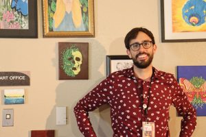 Andrew Barret standing in front of his students' art.