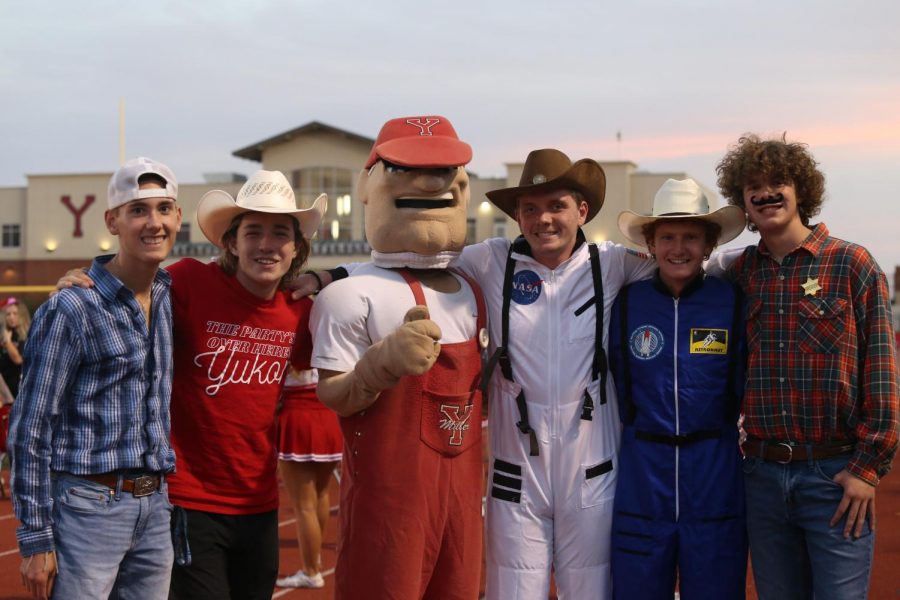 Several members of the flag running group and the newly returned Miller Man pose before the Sept. 24 home game against Norman.