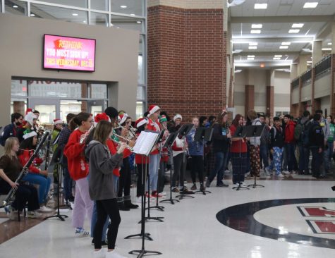 A symphony of sounds echo through the halls as the wind ensemble plays a variety of Christmas songs including Sleigh Ride and A Christmas Festival before second hour on the last day before semester finals.   Students gathered in the rotunda to listen to the jolly tunes and watch the ensemble.