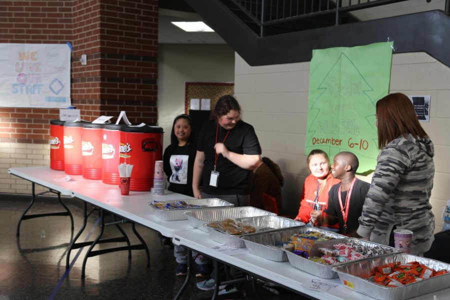 Special Olympians senior Angelic Operario, sophomore Brooke Hayes, paraprofessional Sara Littleton, freshman JT Hayes, and sophomore Rylee Hannah manning the Special Olympics bake sale stand for Unified Soccer.
