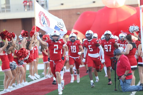 Roaring into competition with a flag, Senior Carter Creach leads the miller football team out the inflatable to hype up the crowd in attendance.  