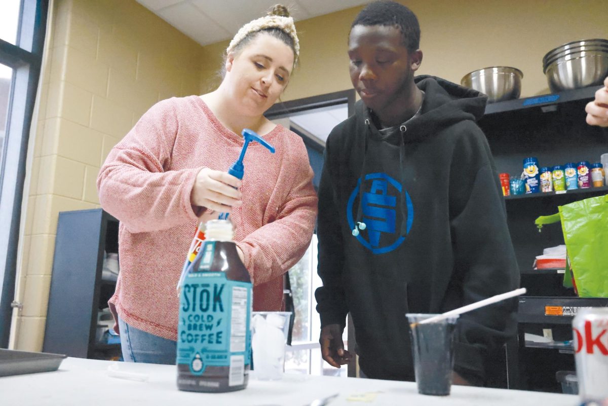 Practice makes perfect. Sponsor Madison Broadbent helps JT Diggs practice making a cold brew coffee. By working alongside one another in a supportive environment Madison hoped everyone would feel valued, capable and accepted. “Their confidence grows, their communication skills increase, and they’re a lot more comfortable asking for things, and greeting (students),” Broadbent said. 